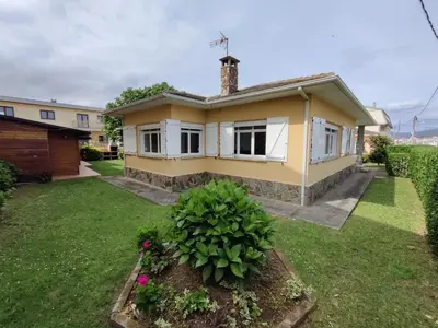 a small yellow house with a yard at Casa A Mariña in Barreiros