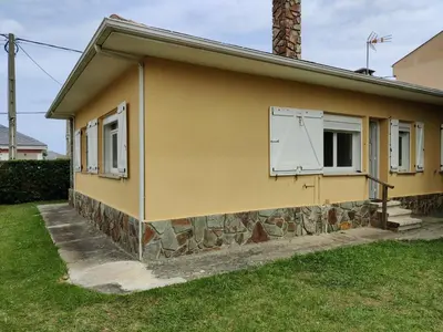 a yellow house with a window on the side of it at Casa A Mariña in Barreiros