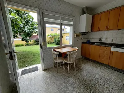 a kitchen with a table and chairs and a window at Casa A Mariña in Barreiros
