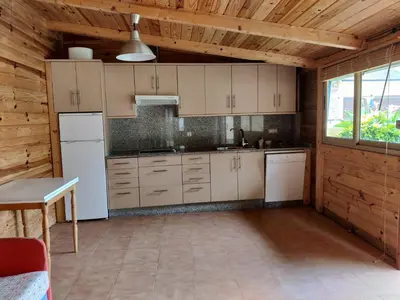 a kitchen with white appliances and a wooden ceiling at Casa A Mariña in Barreiros