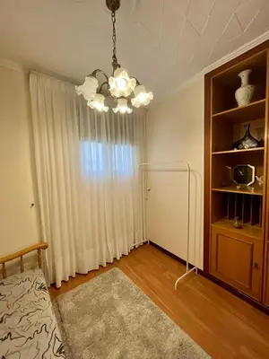 a bedroom with a chandelier and a room with a window at Piso en pleno centro de Miño izquierda in Miño