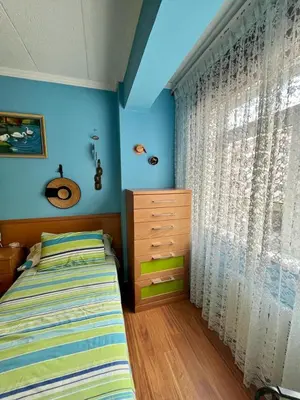 a bedroom with a bed and a dresser and a window at Piso en pleno centro de Miño izquierda in Miño