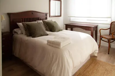 a bedroom with a white bed with two towels on it at Bonito y luminoso apartamento en Rosalía de Castro in Santiago de Compostela