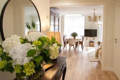 a living room with a table with a vase of flowers at Bonito y luminoso apartamento en Rosalía de Castro in Santiago de Compostela