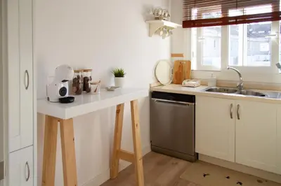 a kitchen with a sink and a counter with a dishwasher at Bonito y luminoso apartamento en Rosalía de Castro in Santiago de Compostela