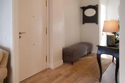 a room with a chair and a table and a door at Bonito y luminoso apartamento en Rosalía de Castro in Santiago de Compostela