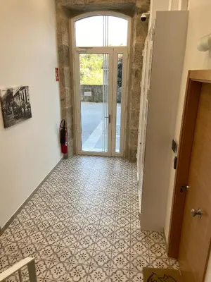 a hallway with a door and a tile floor at Reginita Apartamentos in Arbo