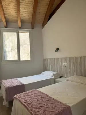two beds in a room with a window at Reginita Apartamentos in Arbo