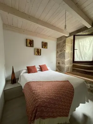 a bedroom with a large bed and a window at As Fontaiñas in Beiro