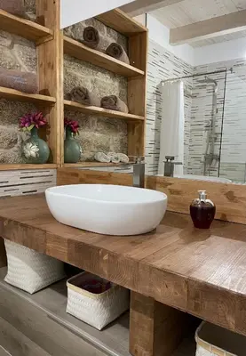 a bathroom with a large white sink on a wooden counter at As Fontaiñas in Beiro