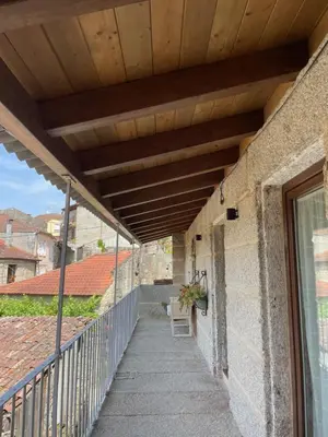 a balcony with awning and a chair on a building at As Fontaiñas in Beiro