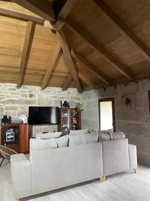 a living room with a couch and a tv at As Fontaiñas in Beiro
