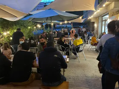 a group of people sitting at tables under umbrellas at Vagabond Vieiras Beds & Communal Dinner Included Albergue LE-210 in La Portela de Valcarce