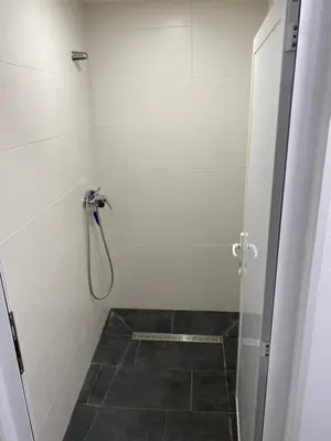 a bathroom with a shower and a tiled floor at Vagabond Vieiras Beds & Communal Dinner Included Albergue LE-210 in La Portela de Valcarce