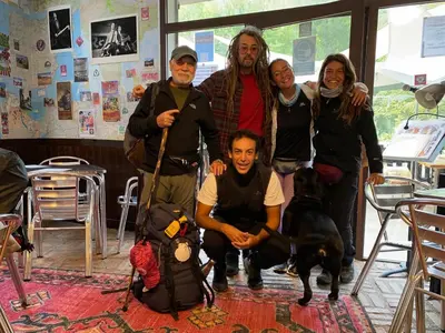 a group of people posing for a picture with a dog at Vagabond Vieiras Beds & Communal Dinner Included Albergue LE-210 in La Portela de Valcarce