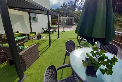 a patio with a table and chairs and an umbrella at Casa Rocha Velha con terraza y piscina particular in Santiago de Compostela