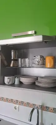 a kitchen shelf with plates and dishes on it at Apartamento Marichu in Melide