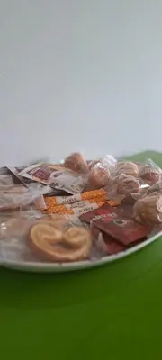 a plate of glazed donuts on a green table at Apartamento Marichu in Melide