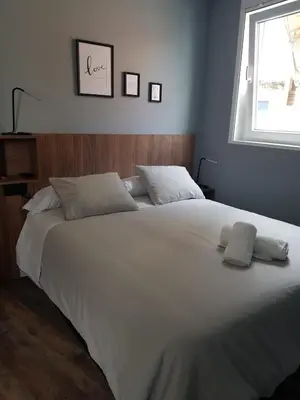 a large white bed in a bedroom with a window at NOARU Apartamentos in Ares