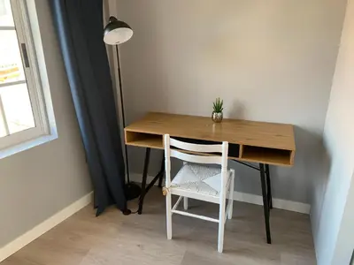 a table with a chair and a desk with a plant on it at NOARU Apartamentos in Ares