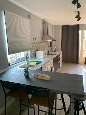 a kitchen with a table with chairs and a counter top at NOARU Apartamentos in Ares
