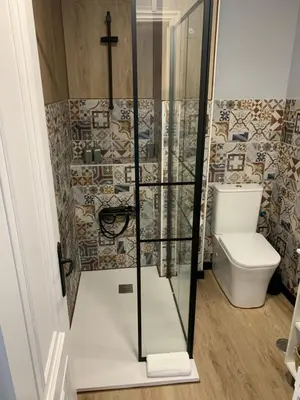 a shower with a toilet and a cross on the wall at NOARU Apartamentos in Ares