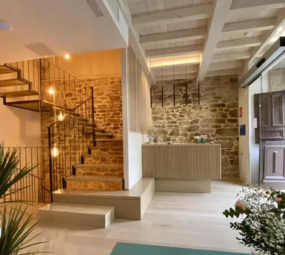 a staircase in a building with a stone wall at Hotel Trina 20 in Palas de Rei