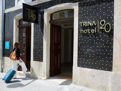 a woman walking out of a hotel with her luggage at Hotel Trina 20 in Palas de Rei