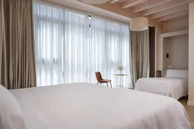 a hotel room with two beds and a window at Hotel Trina 20 in Palas de Rei
