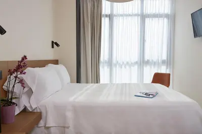 a bedroom with a white bed and a window at Hotel Trina 20 in Palas de Rei