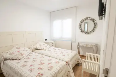 a bedroom with two beds and a mirror on the wall at Arzúa Centro Vivienda de uso turístico in Arzúa
