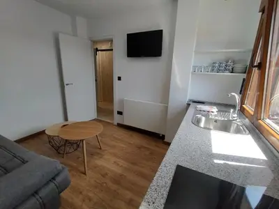 a small living room with a sink and a table at Arzúa Centro Vivienda de uso turístico in Arzúa
