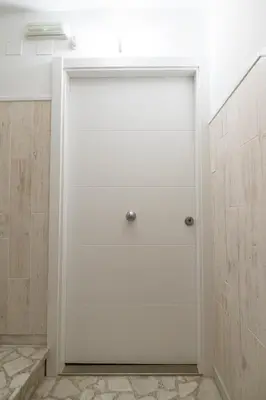 a white garage door in a room with marble floors at Arzúa Centro Vivienda de uso turístico in Arzúa