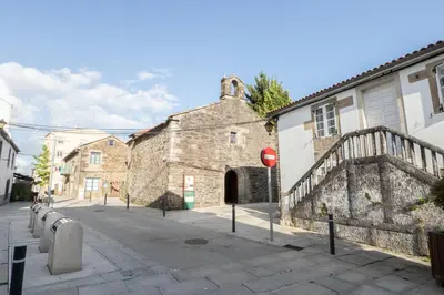 an old stone building on a city street at Arzúa Centro Vivienda de uso turístico in Arzúa