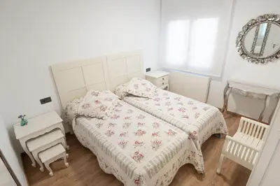 a white bedroom with a bed and a mirror at Arzúa Centro Vivienda de uso turístico in Arzúa