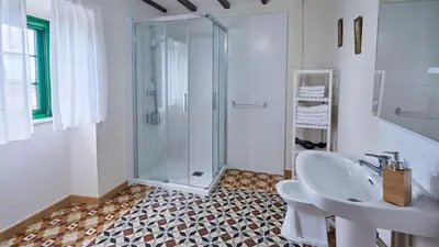 a white bathroom with a sink and a shower at Casa Choureiro Apartamentos Rurales in Navia