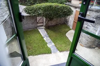 a door open to a yard with a bush at Casa Choureiro Apartamentos Rurales in Navia