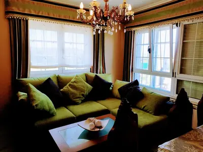 a living room with a green couch and windows at Casa Fina in Foz