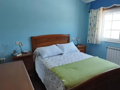 a bedroom with a bed with blue walls and a window at Casa Fina in Foz