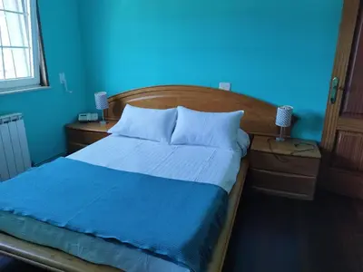 a blue bedroom with a bed and a blue wall at Casa Fina in Foz