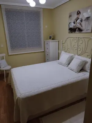 a bedroom with a bed with white sheets and a window at COSTA REINANTE SPA Y PISCINA in San Miguel de Reinante