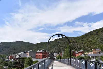 a bridge over a city with mountains in the background at Vivienda de Uso Turístico ABELLA in Matarrosa del Sil