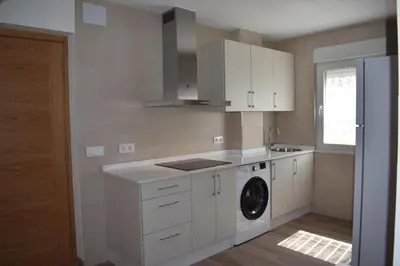 a white kitchen with a washing machine in it at Vivienda de Uso Turístico ABELLA in Matarrosa del Sil