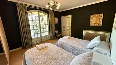 a bedroom with two beds and a chandelier at VILLA DAVID in Horta