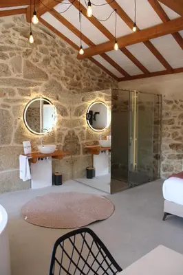 a bathroom with a glass shower and two mirrors at Apartamentos Villa Maceira in Covelo