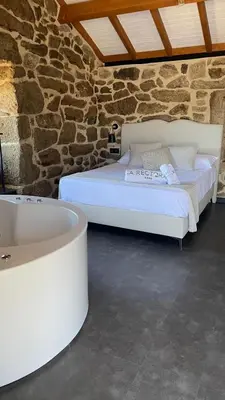 a bedroom with a white bed and a bath tub at Apartamentos Villa Maceira in Covelo