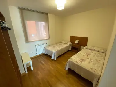 a small room with two beds and a window at dpCristal Calvo Sotelo 164, 4D in Sarria
