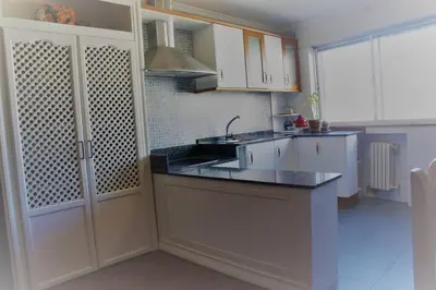 a kitchen with white cabinets and a black counter top at Apartamento Lugo Centro in Lugo