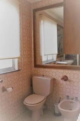 a bathroom with a toilet and a sink and a mirror at Apartamento Lugo Centro in Lugo