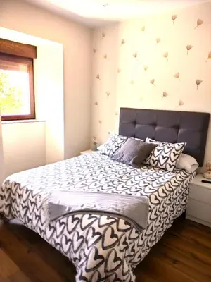 a bedroom with a bed with a black and white comforter at Casa A mi Vera in Covelo